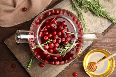 Photo of Tasty hot cranberry tea on wooden table, flat lay