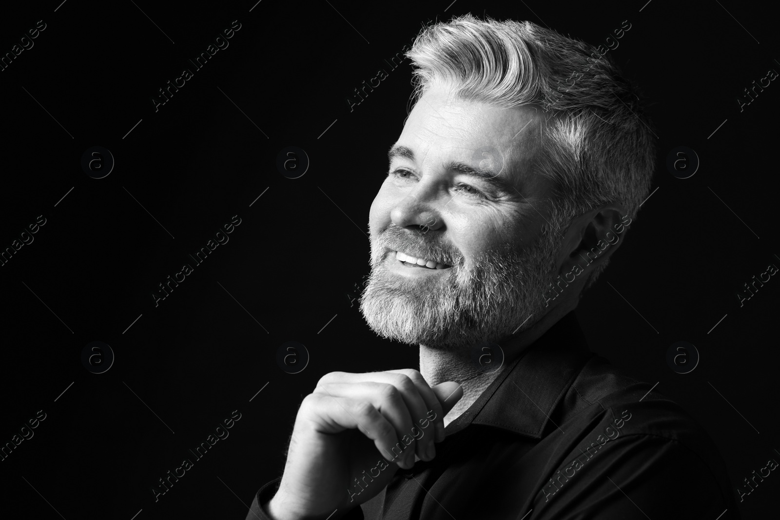 Photo of Portrait of smiling man on dark background, space for text. Black and white effect