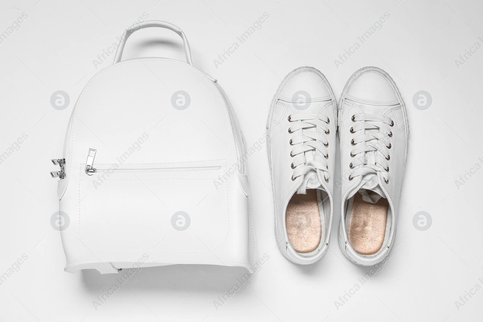 Photo of Stylish casual backpack and sneakers on white background, top view