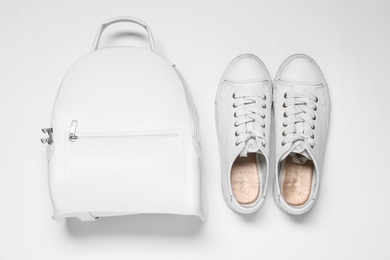 Photo of Stylish casual backpack and sneakers on white background, top view
