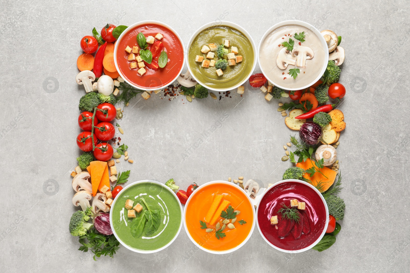 Photo of Various cream soups, ingredients and space for text on grey background, flat lay. Healthy food