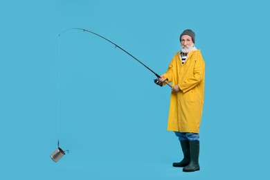 Fisherman with fishing rod and tin can on light blue background, space for text