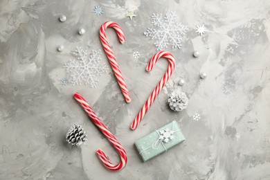 Photo of Flat lay composition with candy canes and Christmas decor on grey table