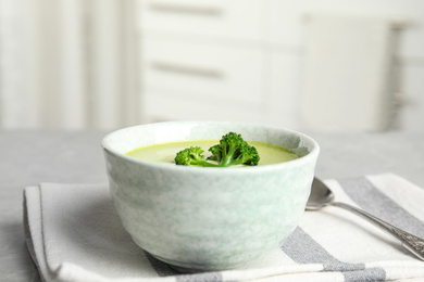 Photo of Delicious broccoli cream soup served on grey table indoors