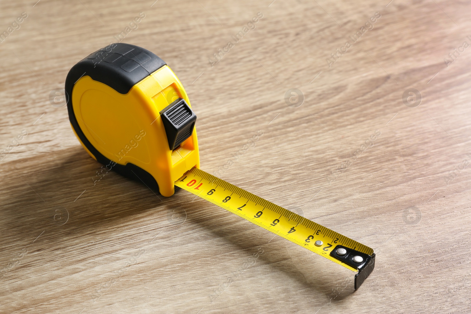 Photo of Metal measuring tape on wooden background. Space for text