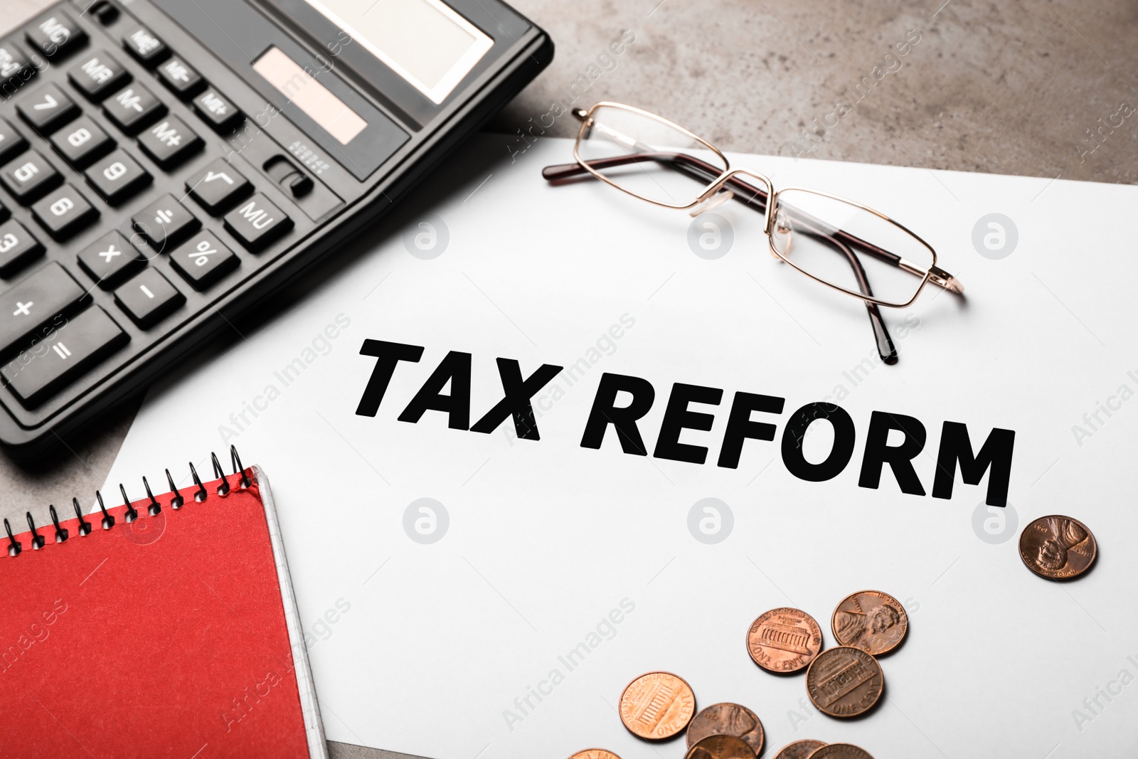 Image of Paper with words TAX REFORM, glasses, calculator and money on table