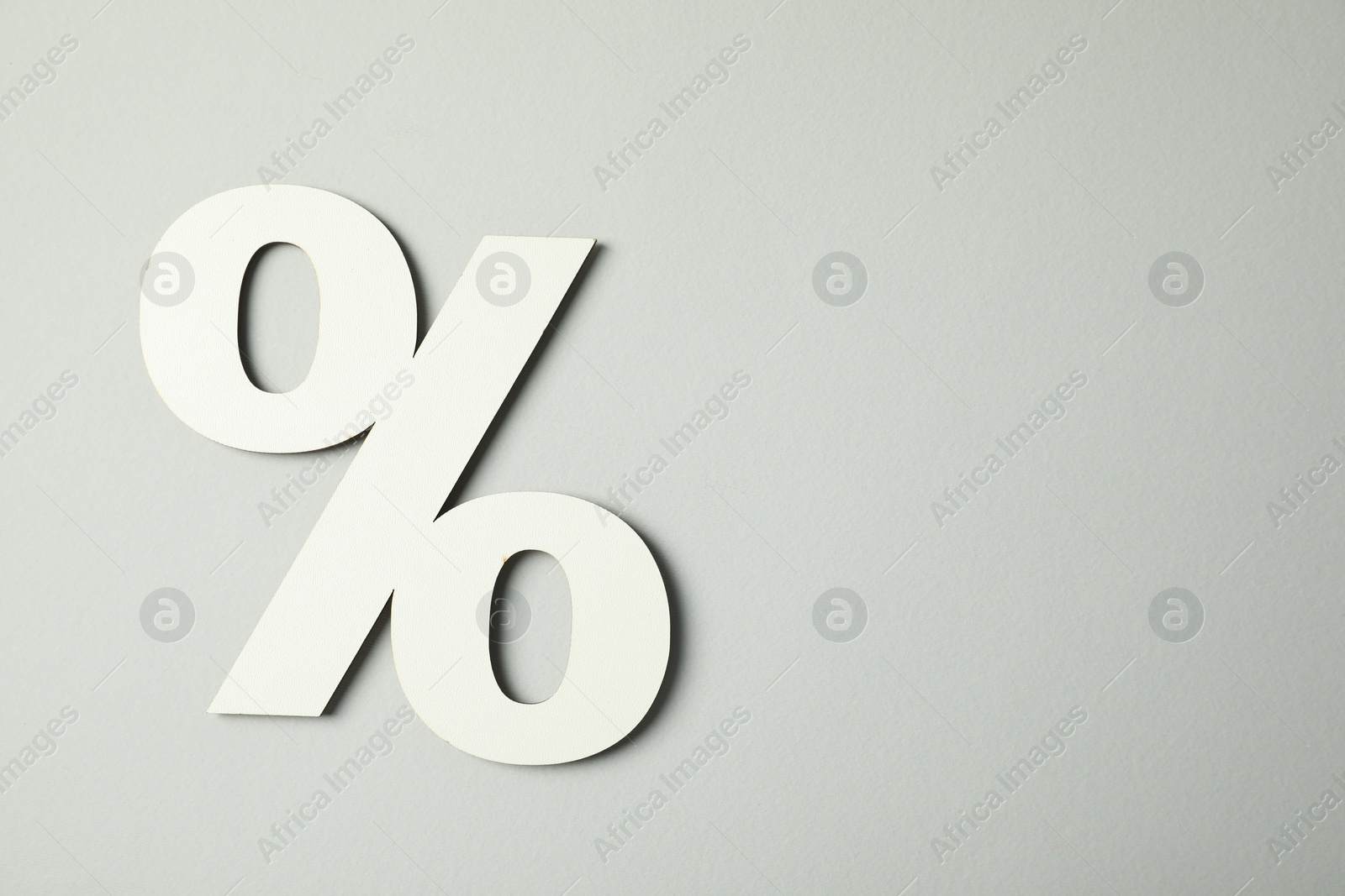 Photo of White percent sign on light grey background, top view. Space for text