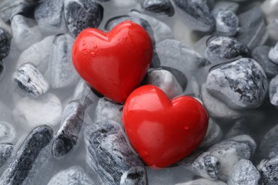Red decorative hearts on stones and water