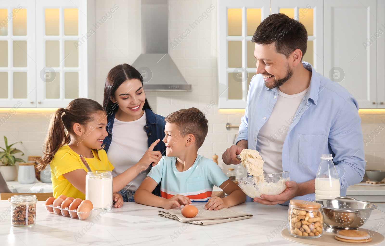 Photo of Happy family cooking together at table in kitchen. Adoption concept