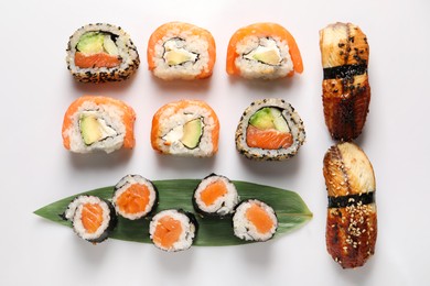 Photo of Different tasty sushi rolls on white background, flat lay