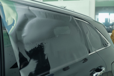 Car window covered with tinting foil, closeup