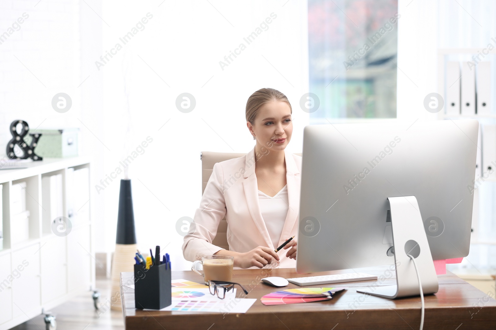 Photo of Female designer working at desk in office