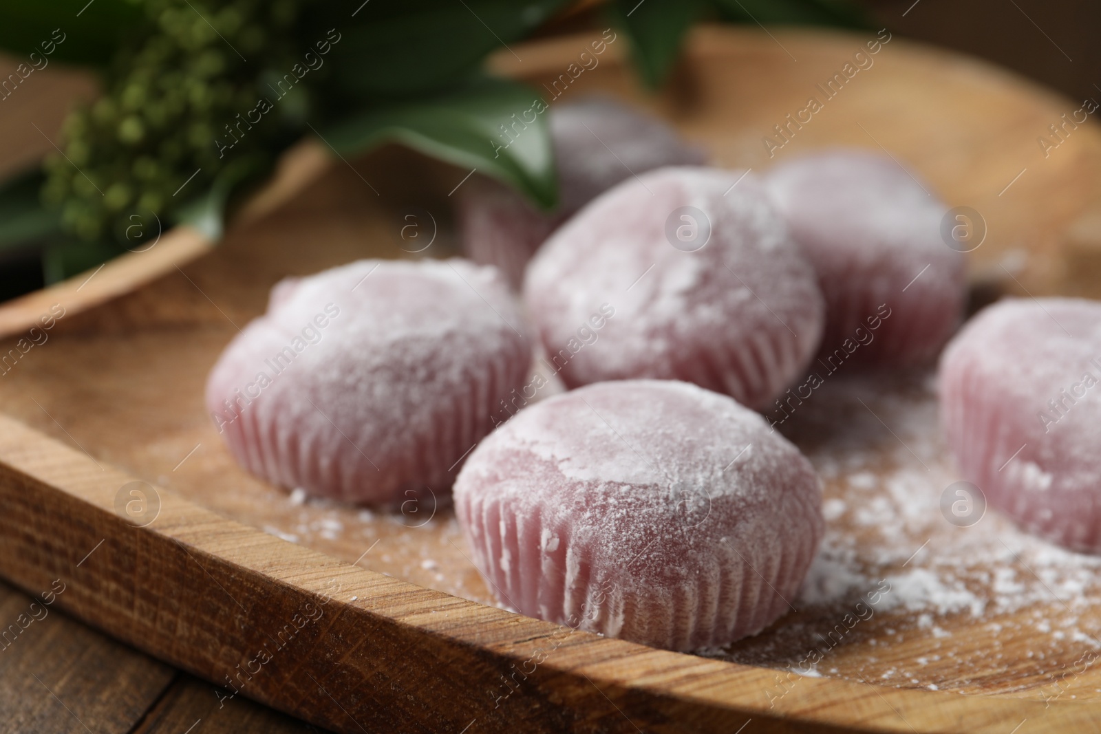 Photo of Delicious mochi on wooden plate, closeup. Traditional Japanese dessert