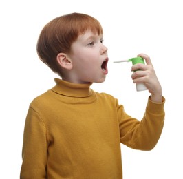 Little boy using throat spray on white background