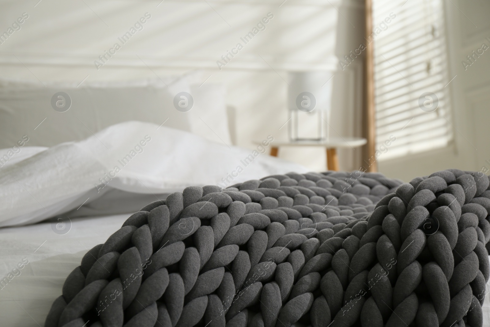 Photo of Soft chunky knit blanket on bed in room