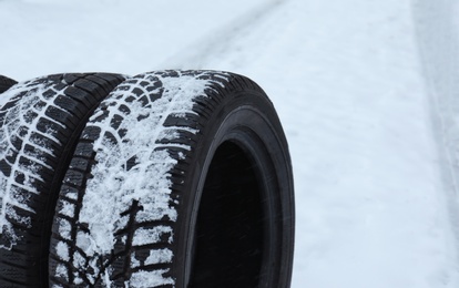 New winter tires on fresh snow, closeup. Space for text