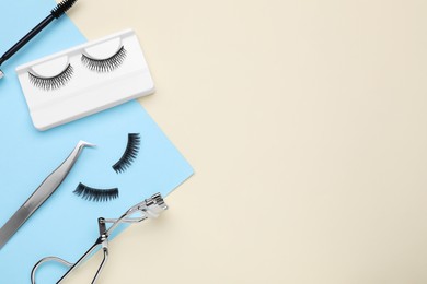 Photo of Flat lay composition with fake eyelashes and tools on color background. Space for text