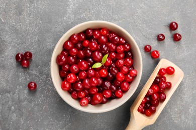 Photo of Fresh ripe cranberries in bowl and scoop on grey table, flat lay