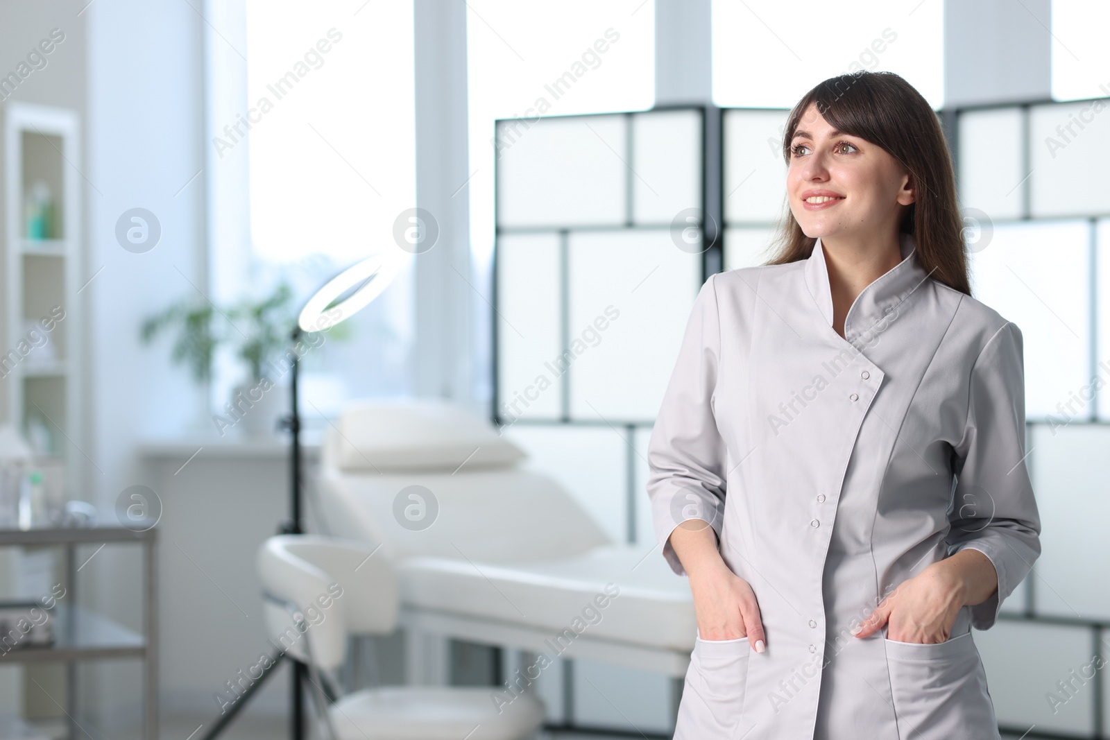 Photo of Cosmetologist in medical uniform in clinic, space for text