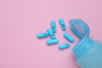 Photo of Bottle and antidepressant pills with funny faces on pink background, flat lay. Space for text