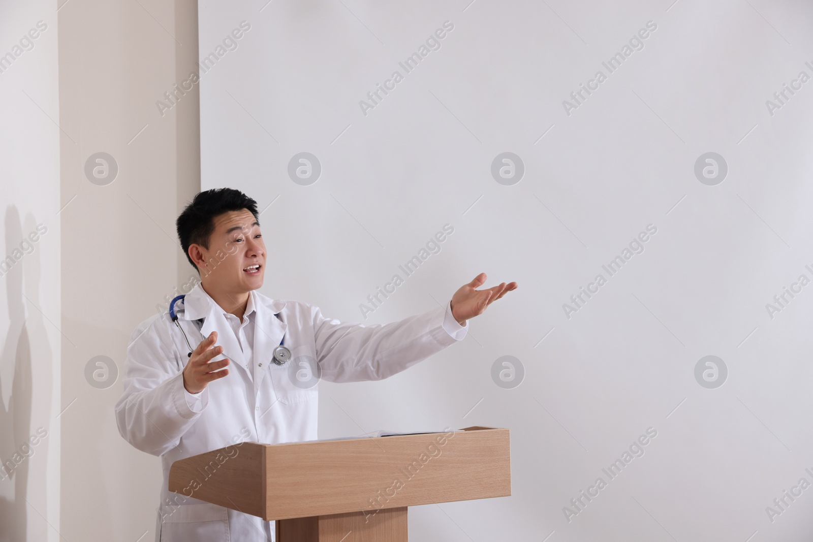 Photo of Doctor giving lecture in conference room with projection screen