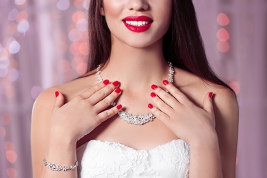 Photo of Beautiful woman with stylish nail polish against blurred lights, closeup
