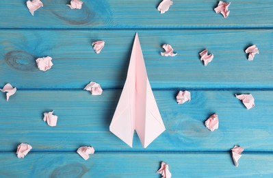 Photo of Flat lay composition with plane and many crumpled pieces of paper on light blue wooden table