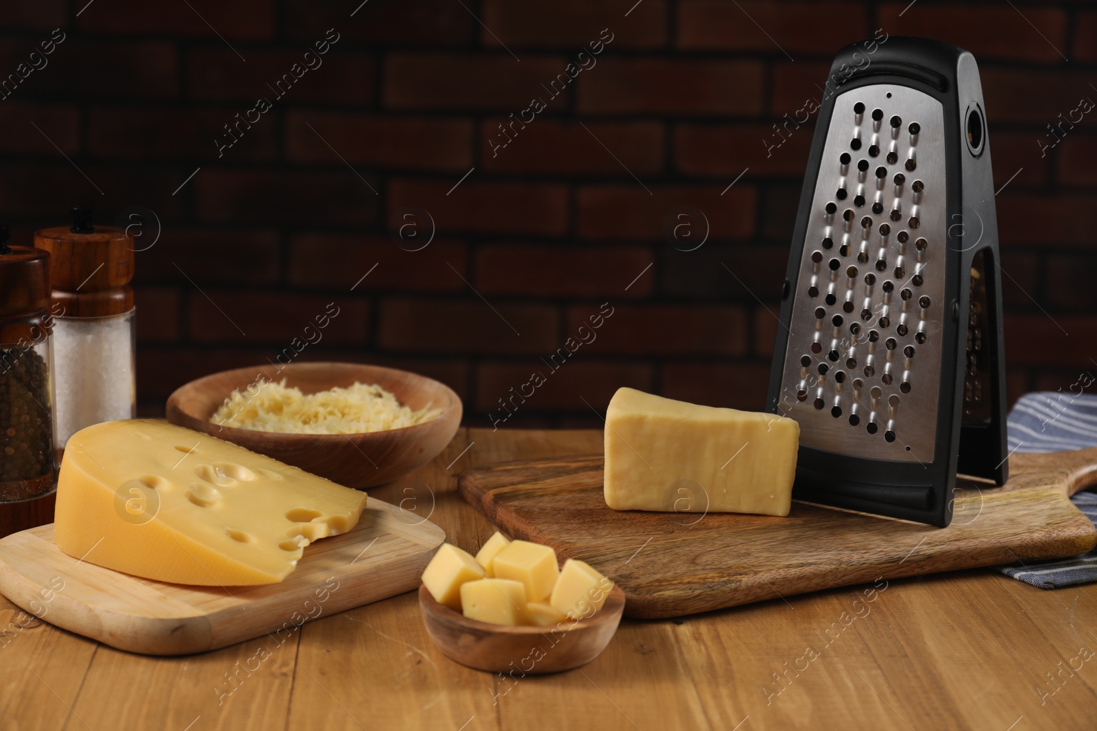 Photo of Different types of cheese and grater on wooden table