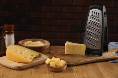 Different types of cheese and grater on wooden table