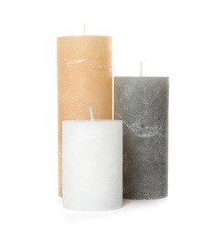 Three color wax candles on white background