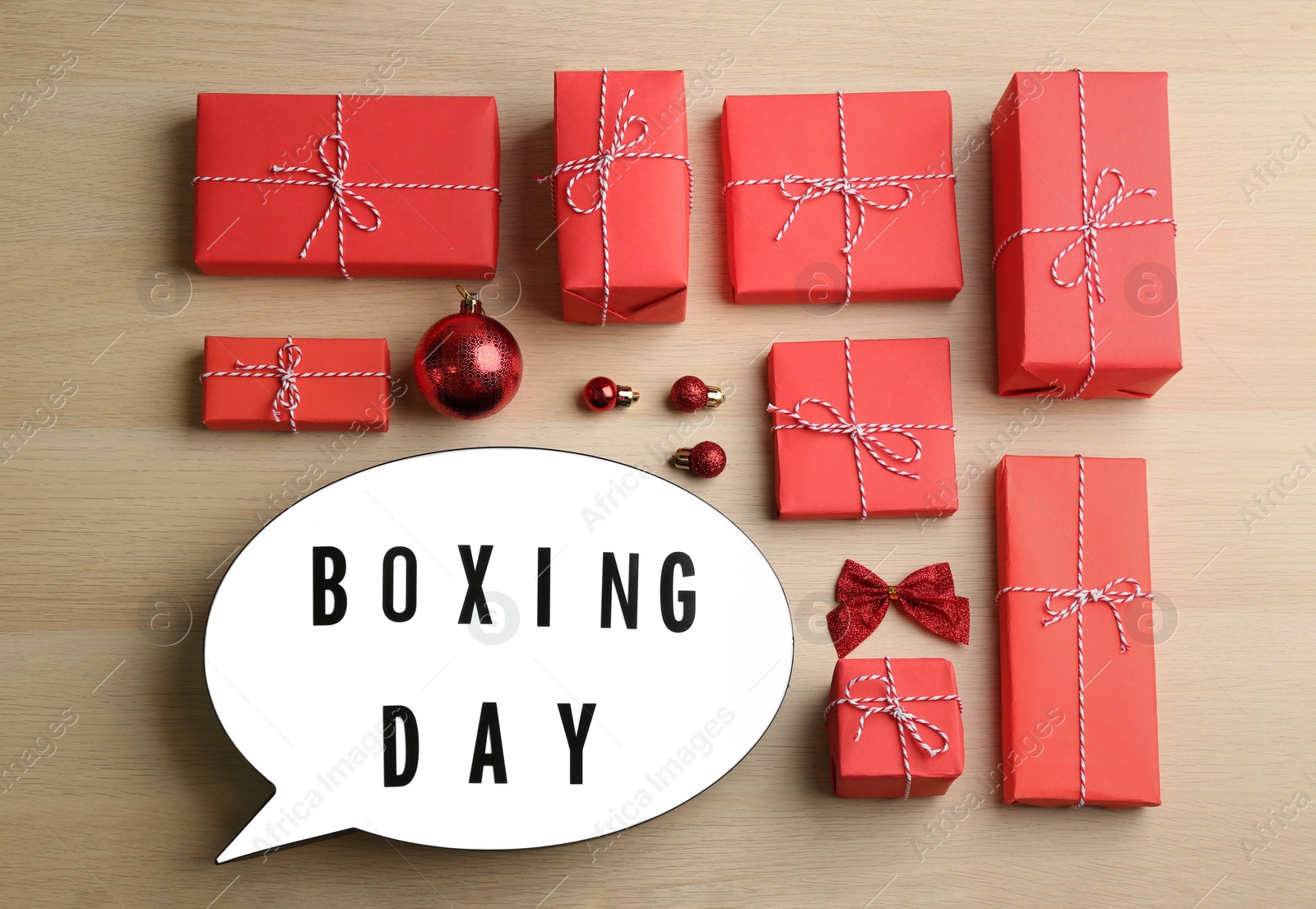 Photo of Flat lay composition with Boxing Day sign and Christmas gifts on wooden table