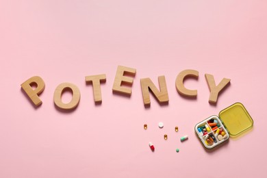 Photo of Word Potency made of wooden letters and pills on light pink background, flat lay