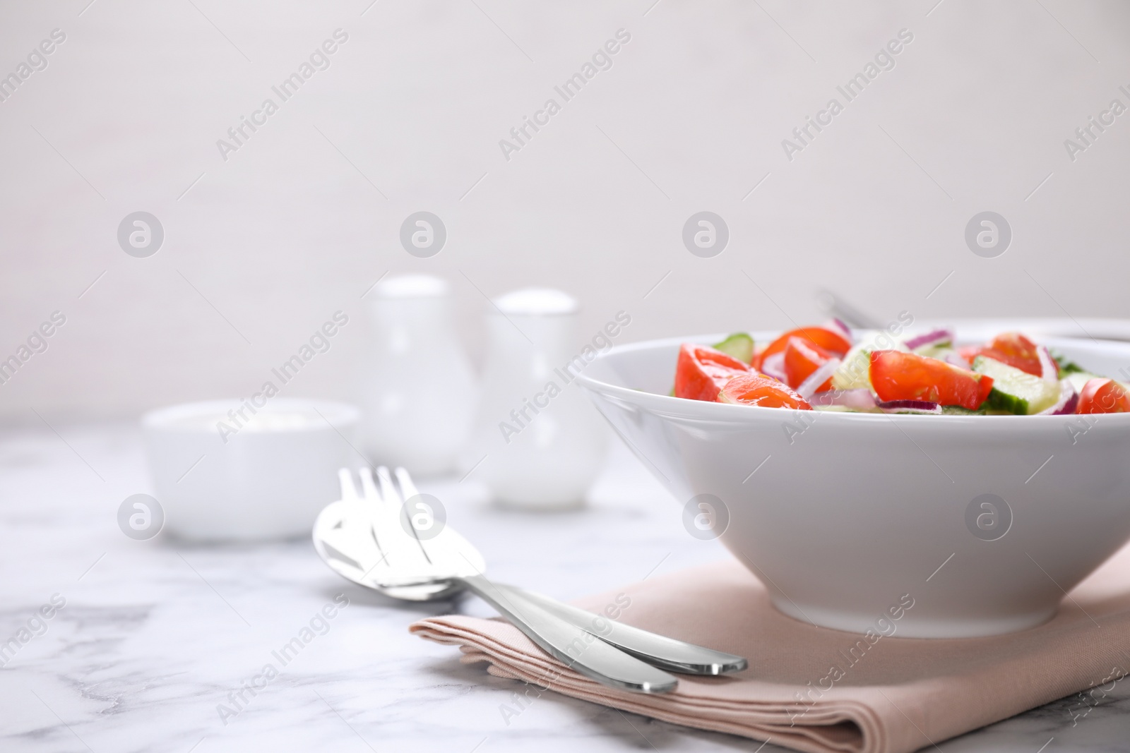 Photo of Delicious fresh cucumber tomato salad served on table, space for text