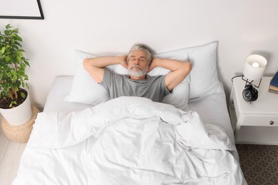 Photo of Senior man sleeping in bed at home