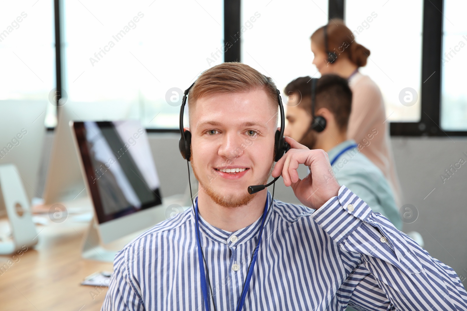 Photo of Technical support operator with colleagues in office