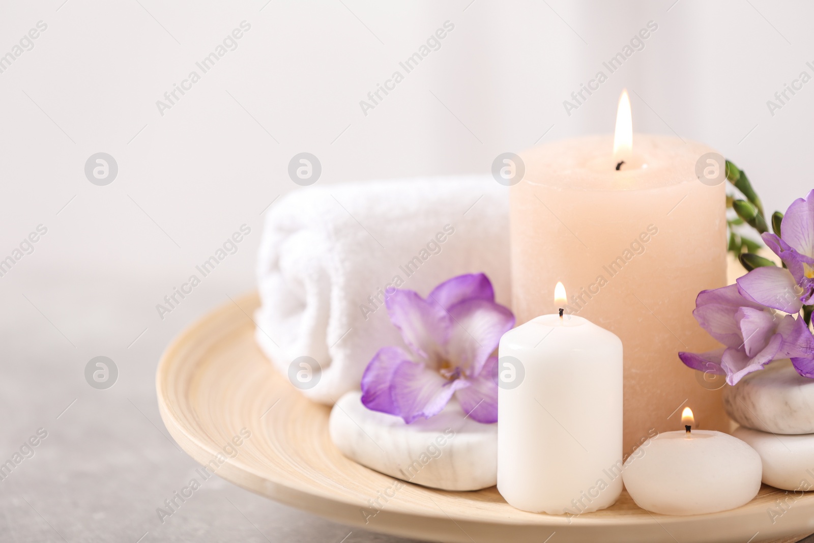 Photo of Beautiful composition with spa stones and burning candles on grey table