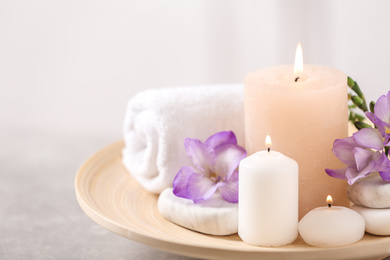 Beautiful composition with spa stones and burning candles on grey table