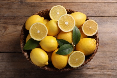 Many fresh ripe lemons on wooden table, above view