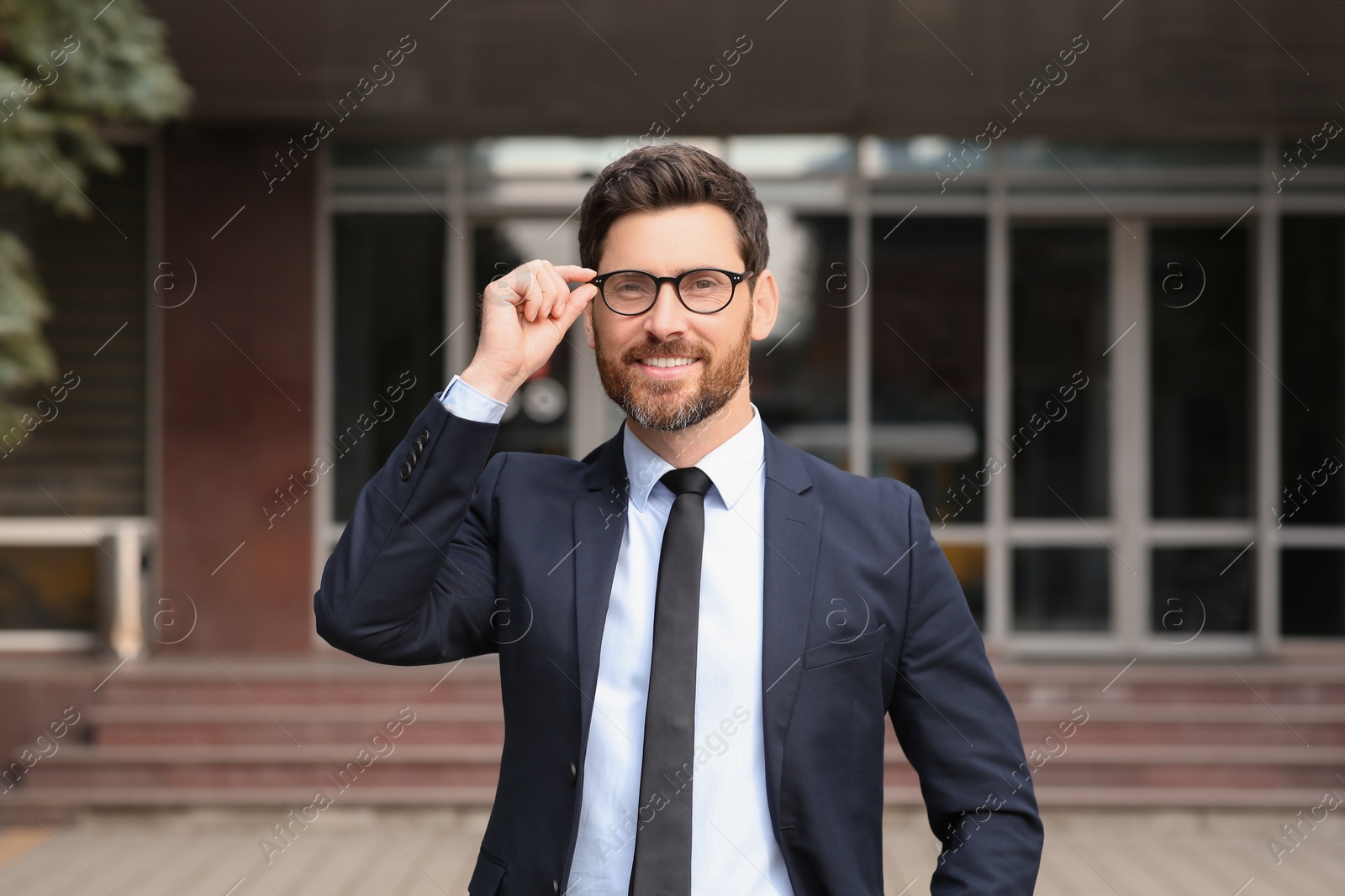 Photo of Handsome real estate agent in nice suit outdoors