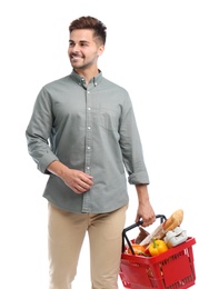 Young man with shopping basket full of products isolated on white