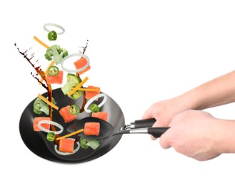 Image of Man tossing ingredients in wok on white background, closeup