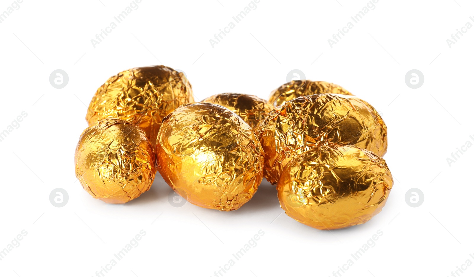 Photo of Chocolate eggs wrapped in golden foil on white background