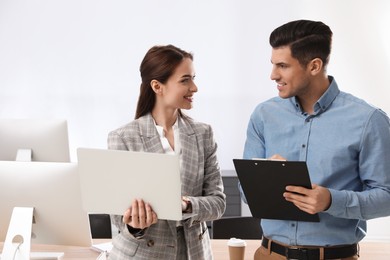 Businesswoman helping intern with work in office