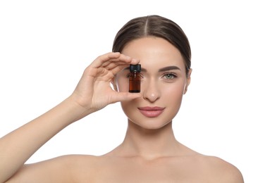 Young woman with bottle of essential oil on white background