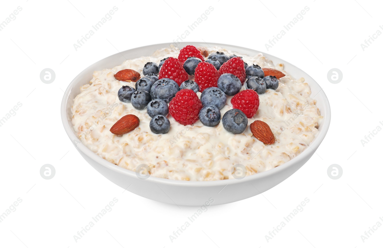 Photo of Tasty boiled oatmeal with berries and almonds in bowl isolated on white