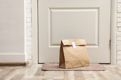 Photo of Paper bag on door mat near entrance indoors