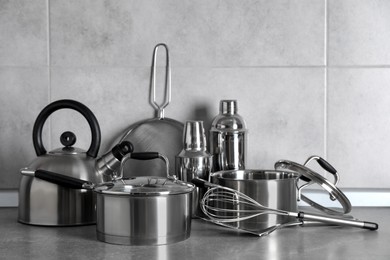 Photo of Set of different cooking utensils on grey countertop in kitchen