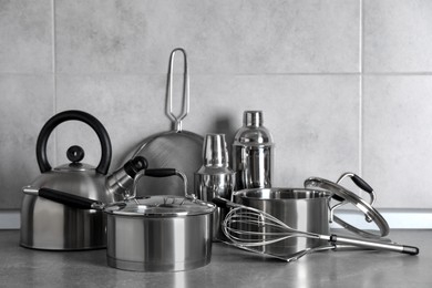 Set of different cooking utensils on grey countertop in kitchen