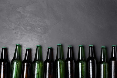 Tasty beer in bottles on black background, flat lay. Space for text