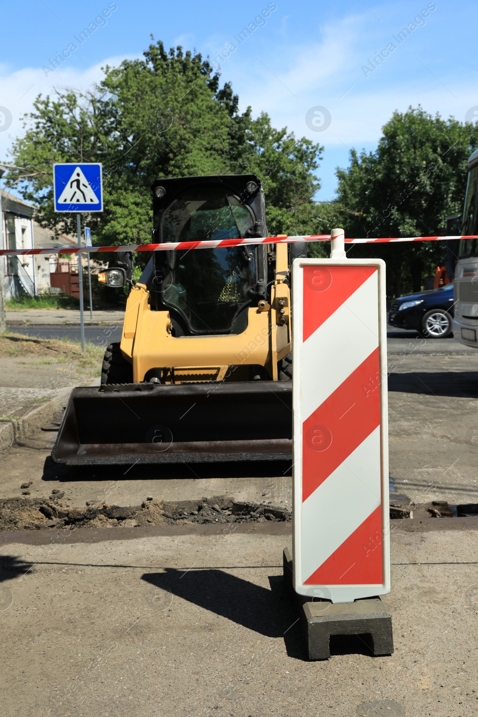 Photo of Skid loader on city street. Road repair